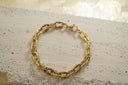 Gold-tone bracelet with thick oval links, ridged side sections and a clasp.