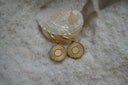 Alternate view: gold-tone hoop earrings with flat circular disc charms decorated with radiating sunray lines.