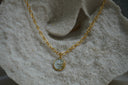 Alternate view: gold-tone oval-link necklace with a sun face and curved rays on a pale disc.