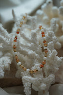 Alternate view: necklace with orange, peach and white beads separated by gold-tone spacers.