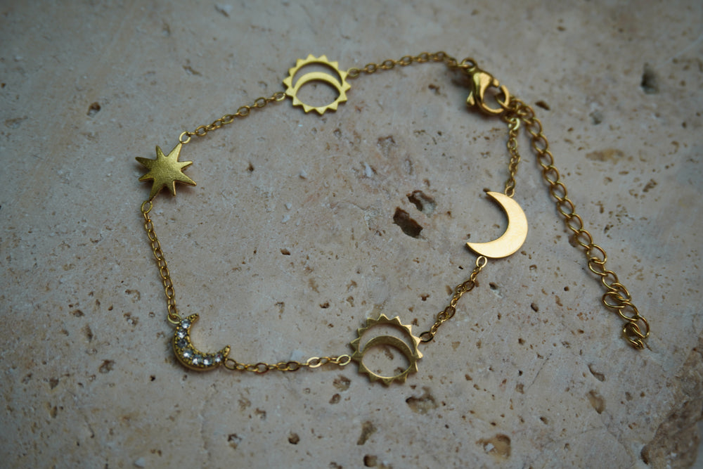 Alternate view: gold-tone chain bracelet with crescent moons, pointed stars and open sun motifs.