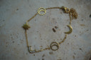 Gold-tone chain bracelet with crescent moons, pointed stars and open sun motifs.