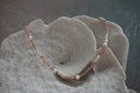 Necklace with peach and lilac faceted beads, stacked white discs, rounded white beads and gold-tone accents.