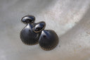 Silver-tone stud earrings with smooth oval tops and ridged fan-shell shapes.