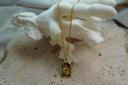 Alternate view: gold-tone chain necklace with an irregular arched tag, raised four-point star motif and radiating lines.