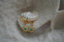 Gold-tone hoop earrings with sunburst charms and blue centres marked by dark vein-like lines.