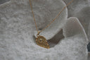 Gold-tone necklace with an asymmetric pointed pendant, radiating lines and clear accents at its oval centre.