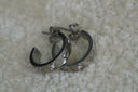 Alternate view: silver-tone flat-band open hoops with heart outlines and round clear accents; posts and backs visible.