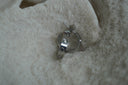 Silver-tone flat-band open hoops with heart outlines and round clear accents; posts and backs visible.