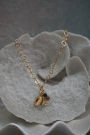 Gold-tone open-link necklace with western hat and boot charms and dark brown beads.