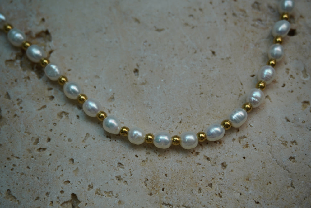 Alternate view: necklace with white oval beads alternating with small gold-tone spheres.