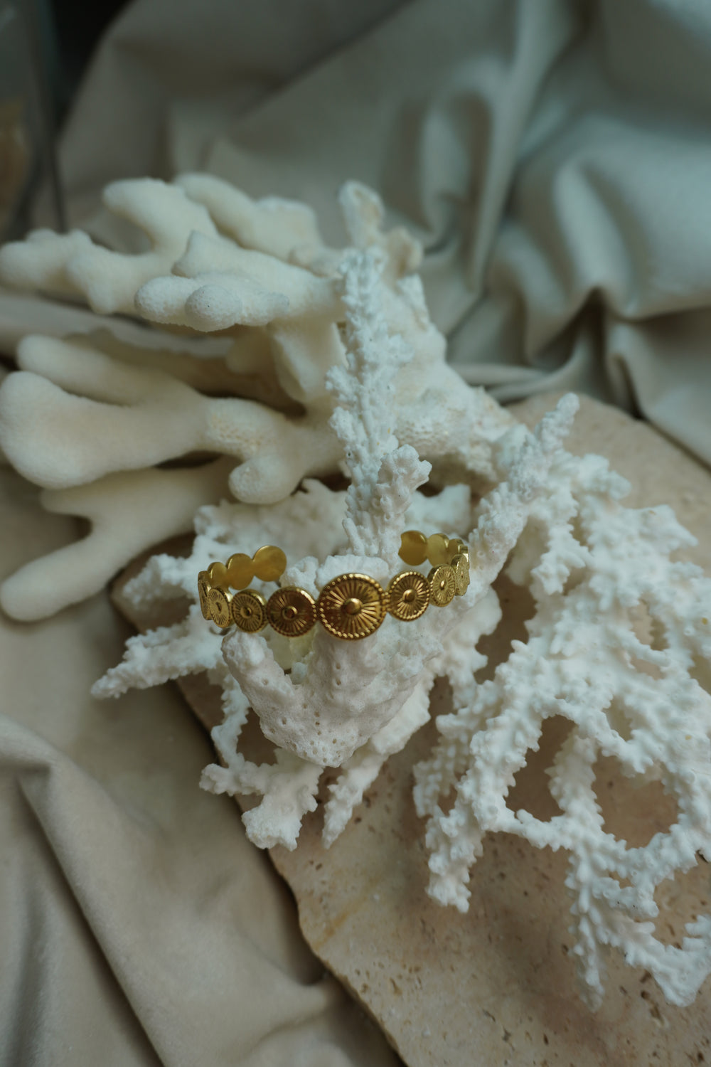 Gold-tone open cuff formed from graduated discs with radiating lines and raised centres.