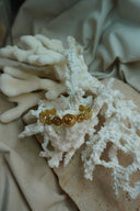 Gold-tone open cuff formed from graduated discs with radiating lines and raised centres.