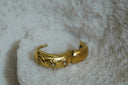 Alternate view: gold-tone hoops with raised sun, crescent and eye motifs and clear accents.