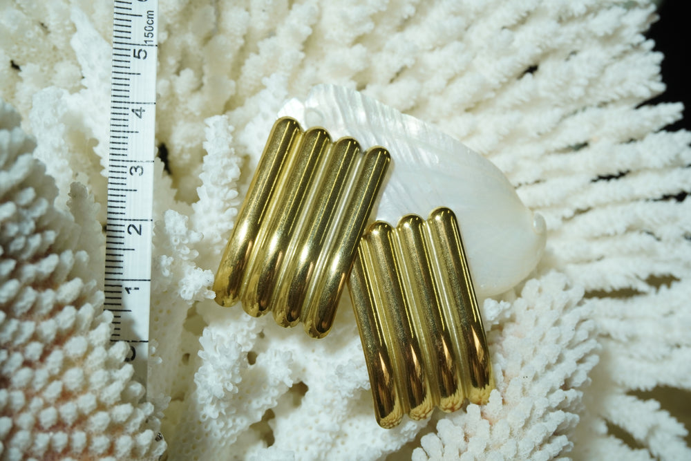 Alternate view: gold-tone rectangular stud earrings with four parallel rounded ridges, photographed beside a ruler.