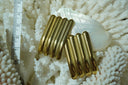 Gold-tone rectangular stud earrings with four parallel rounded ridges, photographed beside a ruler.