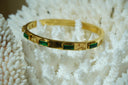 Alternate view: gold-tone hinged bangle with green rectangular faceted accents.