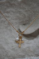 Alternate view: gold-tone necklace with a patterned cross charm and white oval beads suspended from a front ring.