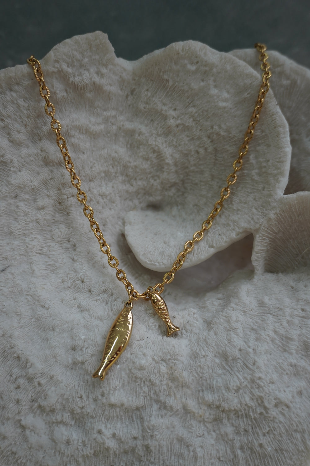 Gold-tone link necklace with two hanging fish-shaped charms.